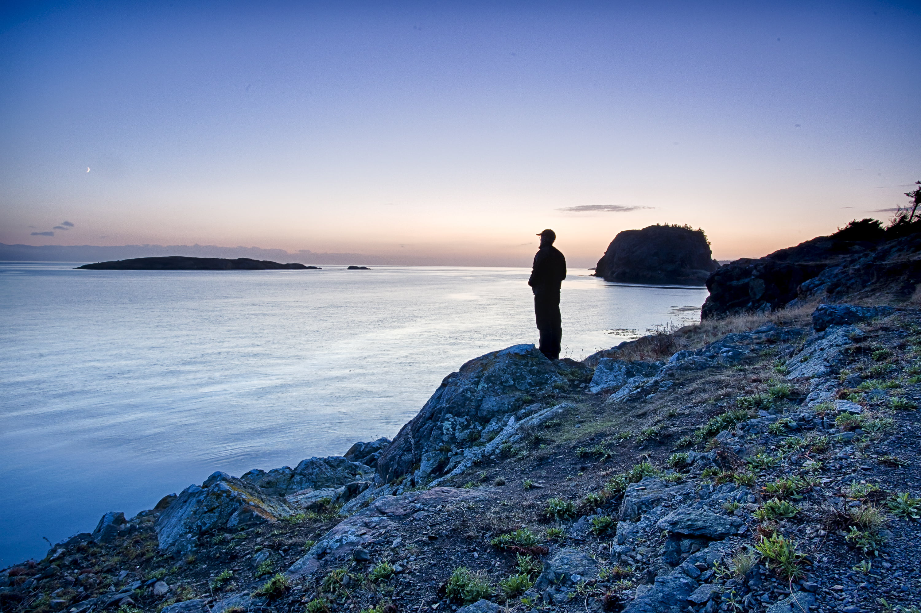 silhouette of person wearing cap standing near blue sea during daytime, washington, san juan islands national monument, washington, san juan islands national monument
