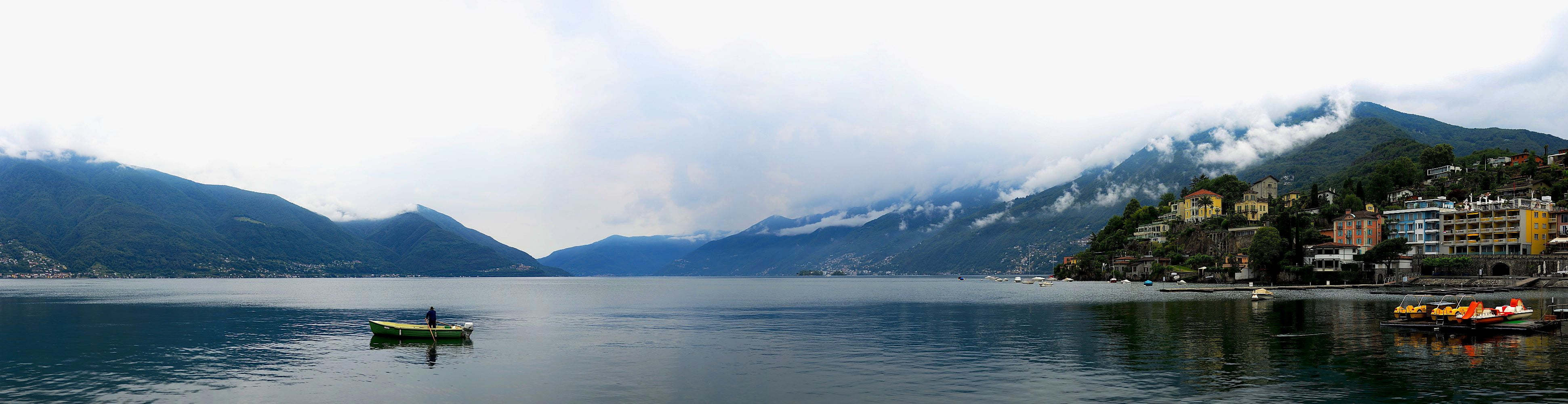 panoramic photo of person riding on boat, lago maggiore, lago maggiore