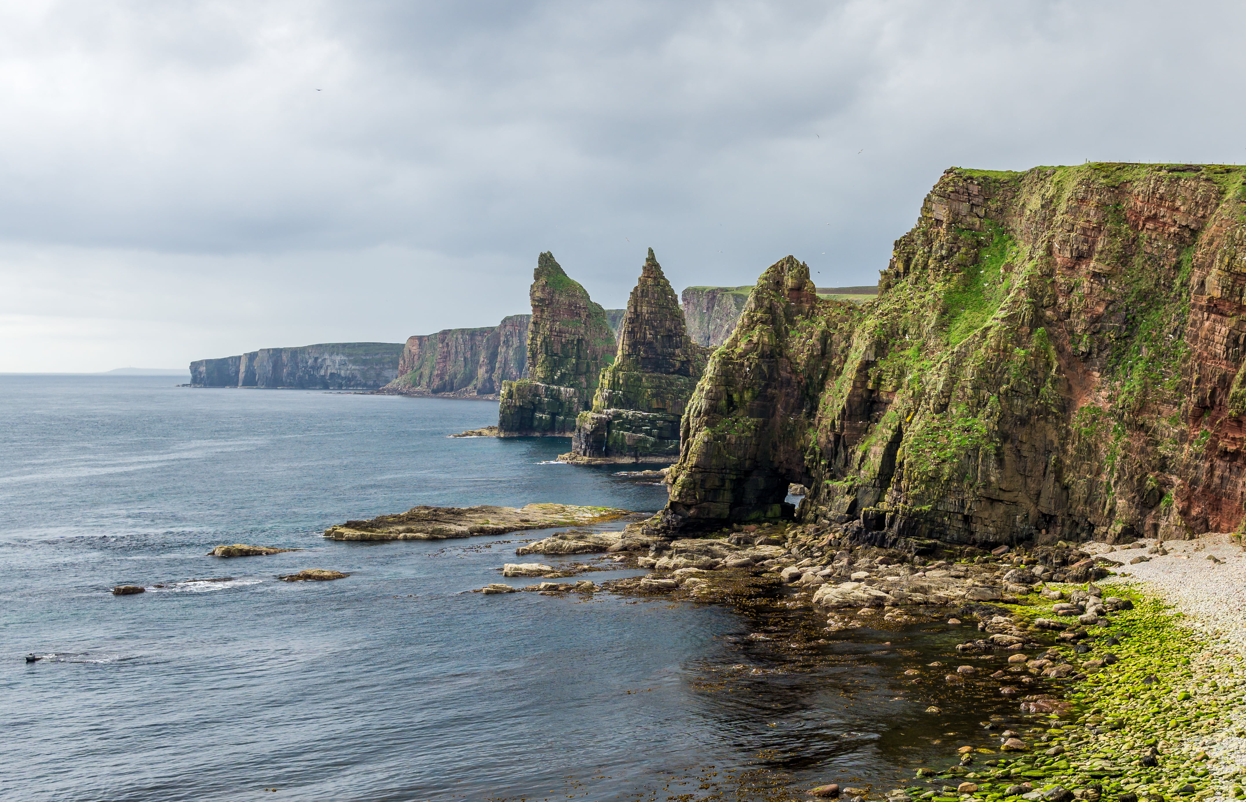 rocky mountain and ocean under white clouds, Duncansby Head, Scotland