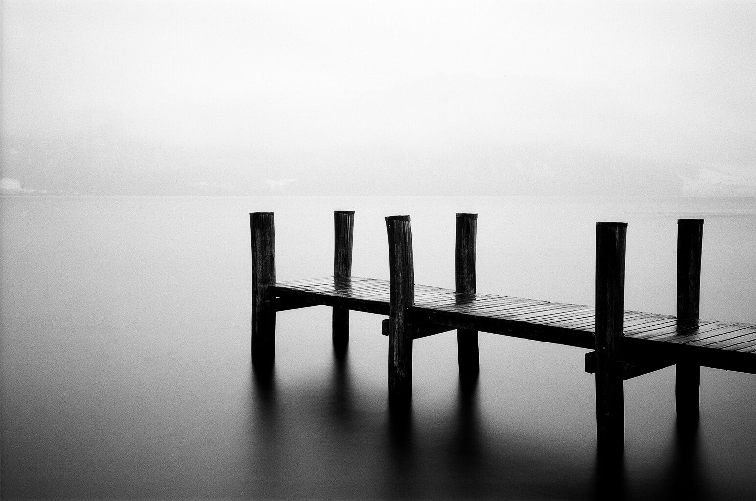 gray scale photography of wooden dock on body of water, weggis, ilford, weggis, ilford