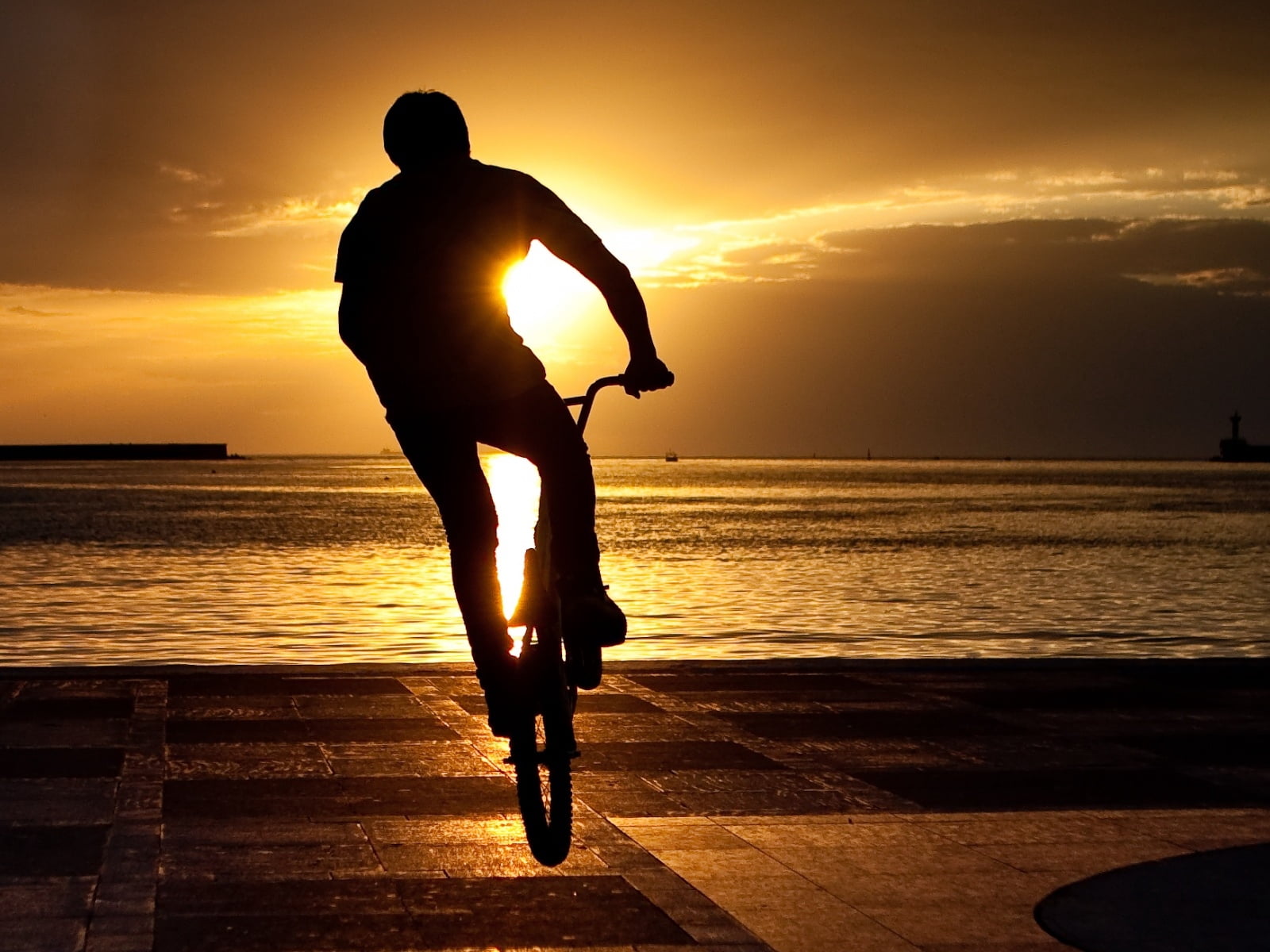 silhouette of man riding bike, bicyclist, trick, jump, extreme