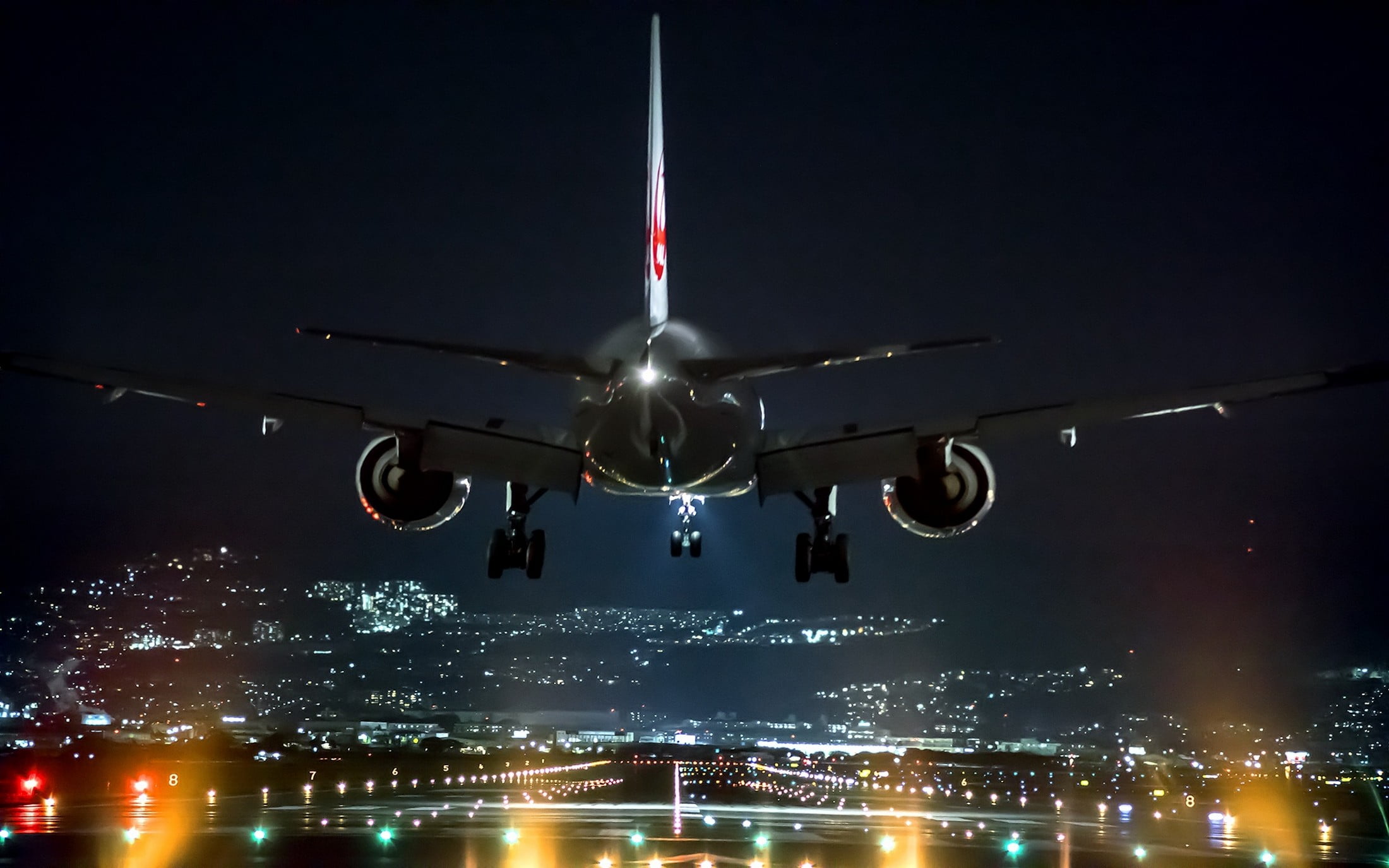 black and white airplane, passenger plane getting ready on runway to land at night time