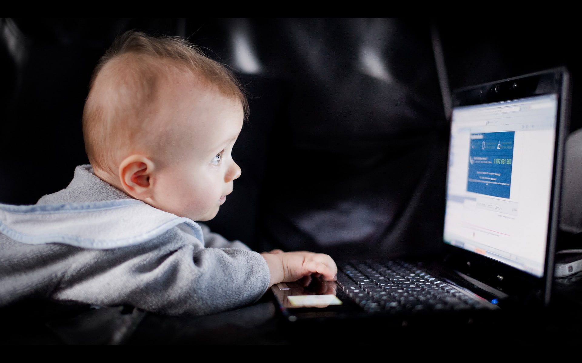 Cute baby boy use laptop, black laptop computer