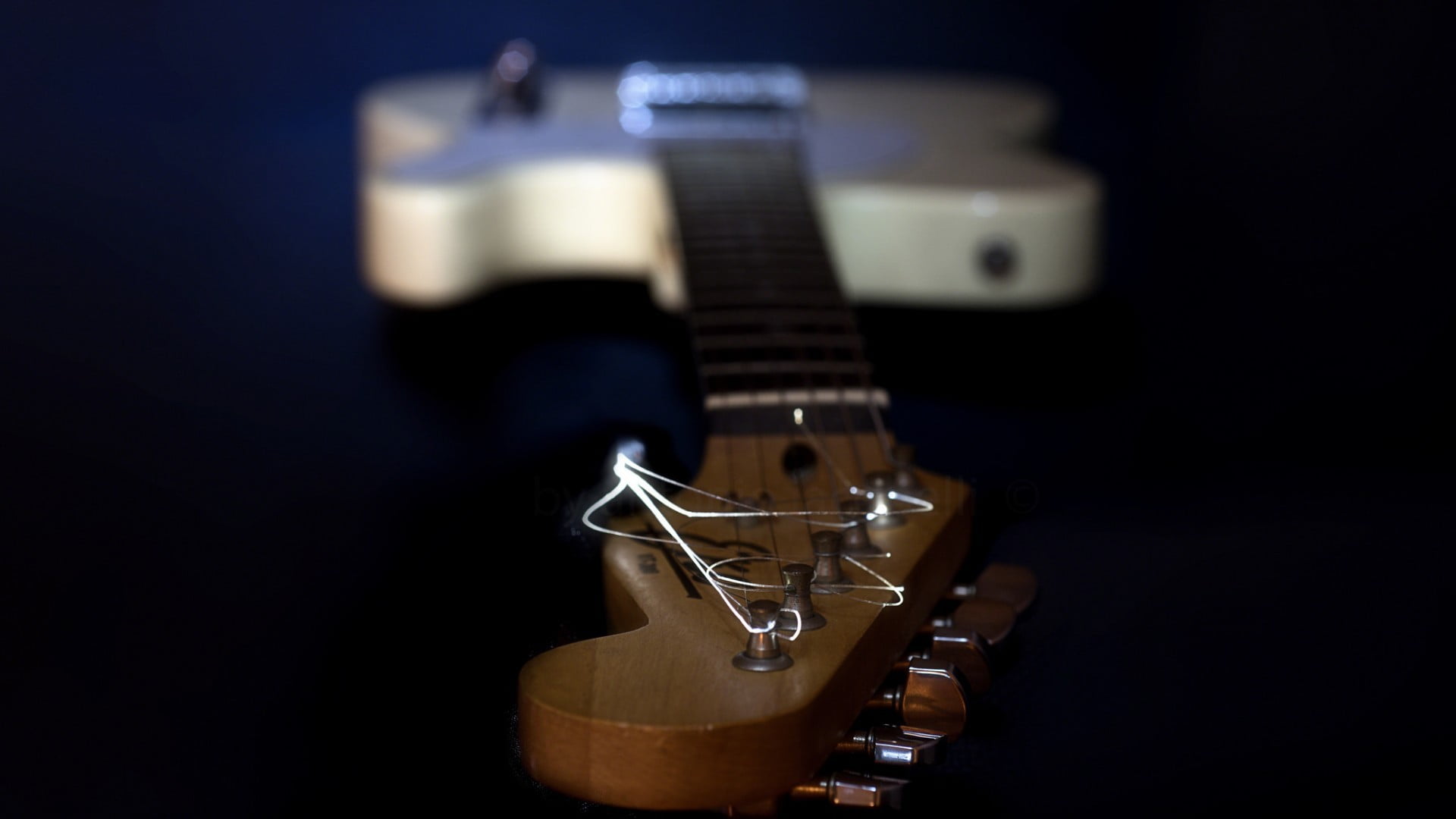 selective focus photography of brown guitar headstock, musical instrument