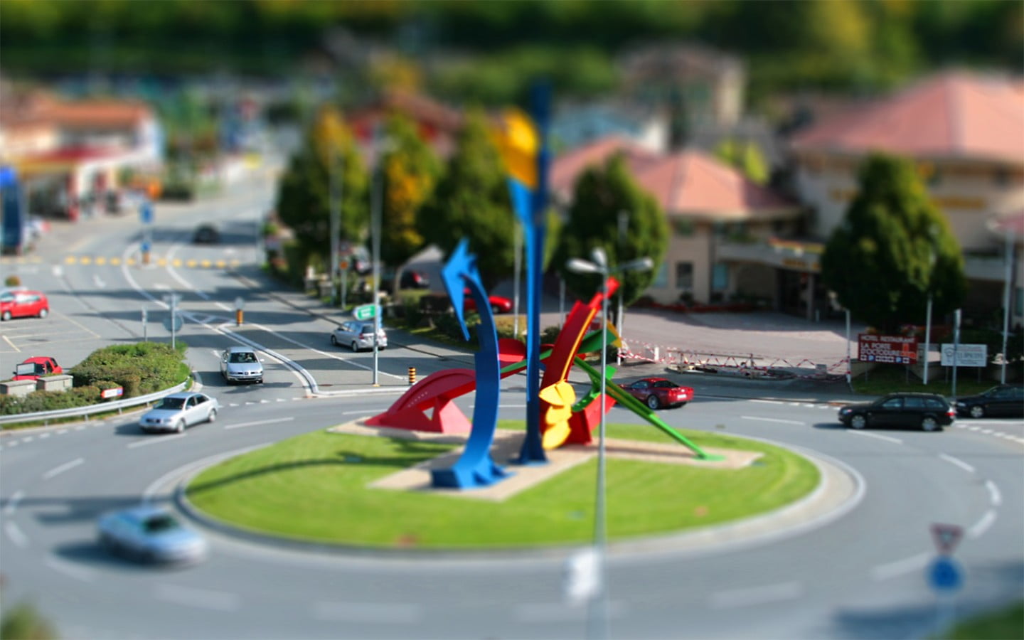 city tilt shift photo, multicolored diorama of round about with cars and house