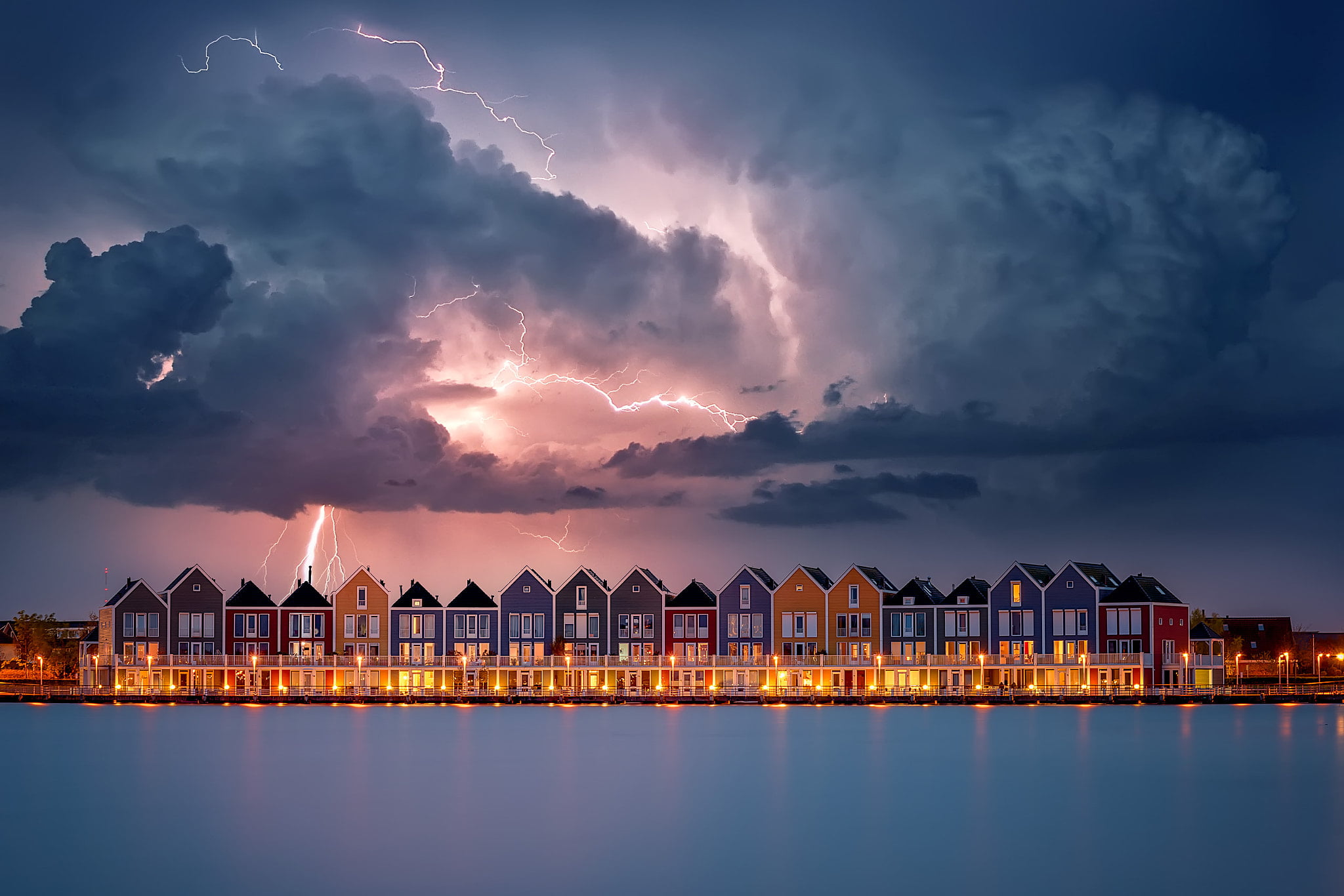 assorted-color houses with lightning from the sky panoramic photography