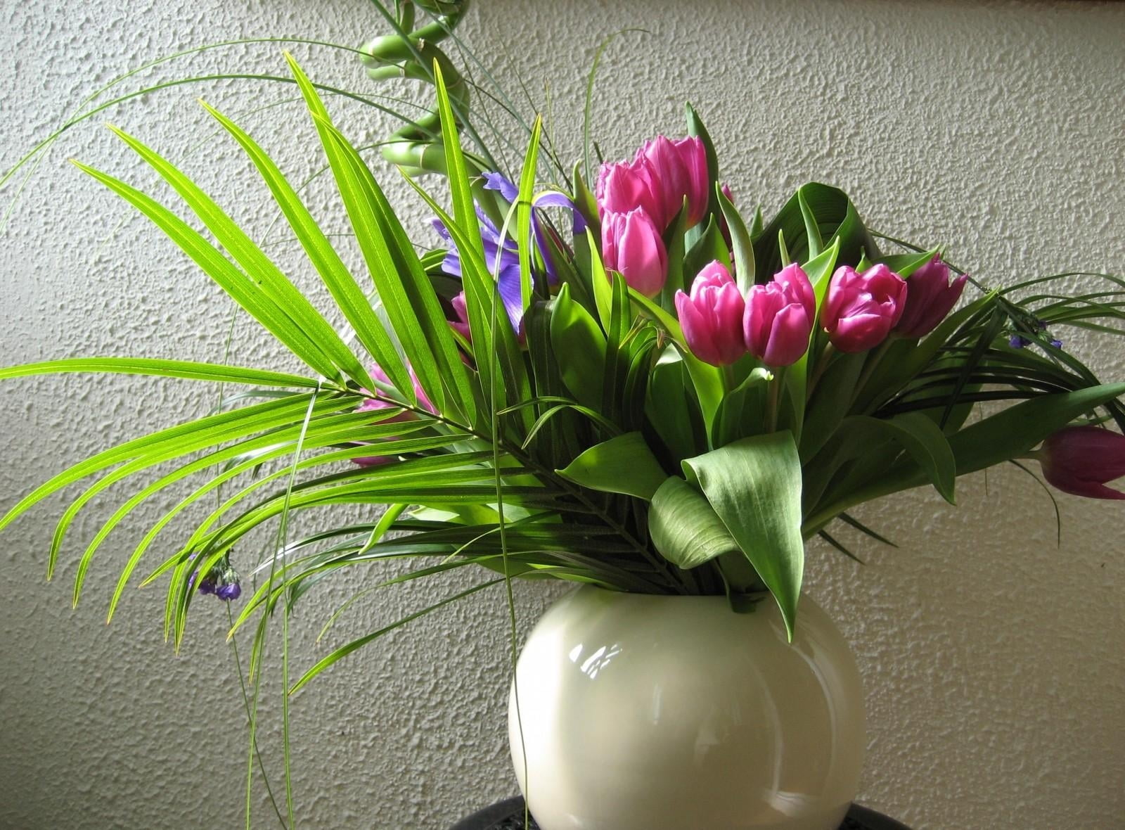 pink tulip flowers and green majesty palm leaves centerpiece