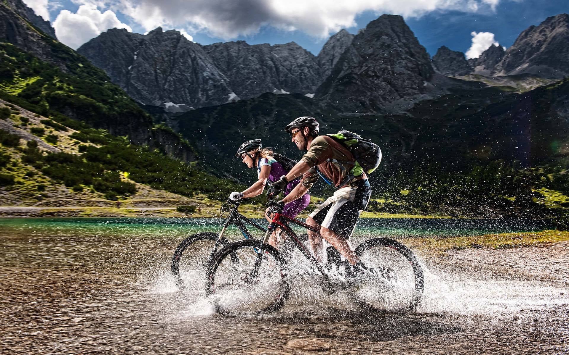 two black hardtail bicycles, alps, cyclists, spray, mountains