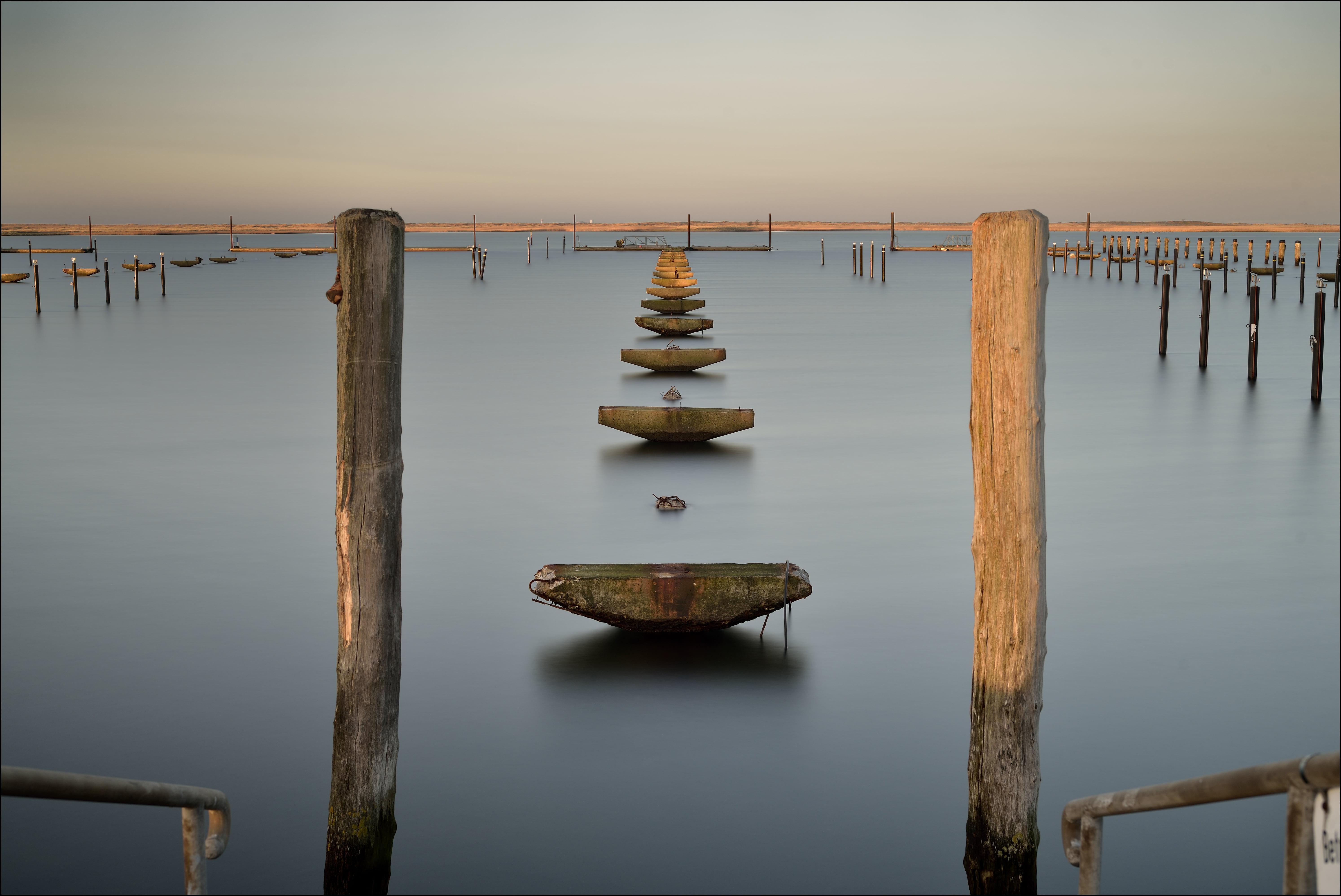 photo of two brown wooden posts, harbour, long, time exposure