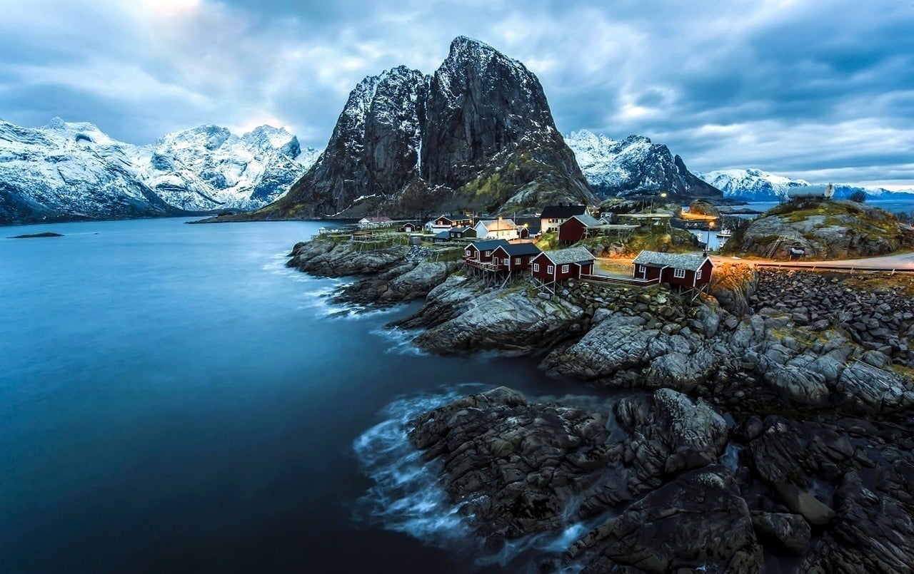 houses near calm water and ice-capped mountains, winter, coast