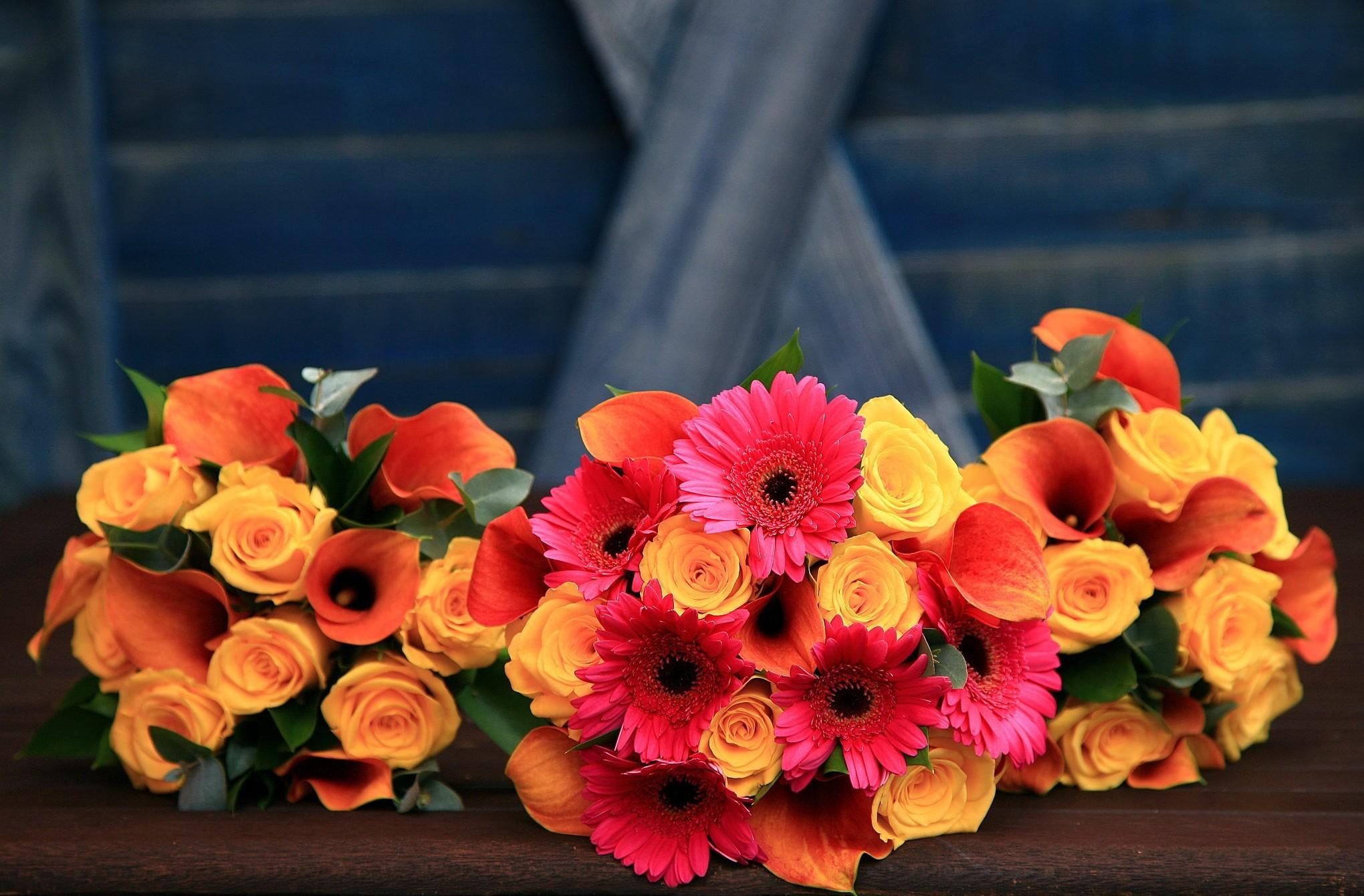 three yellow rose flowers, orange calla lilies, and pink Gerbera daisy flowers bouquets