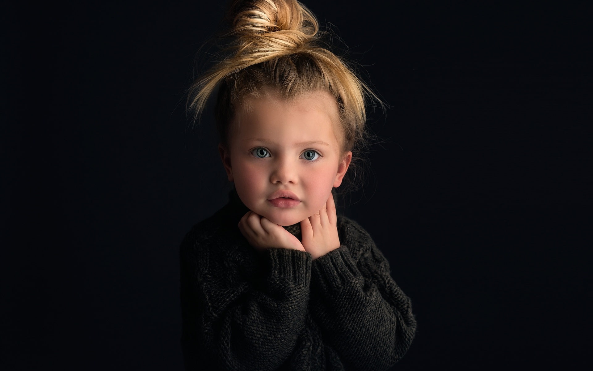 Cute baby girl, portrait, blonde, black background, girl's black knit sweater
