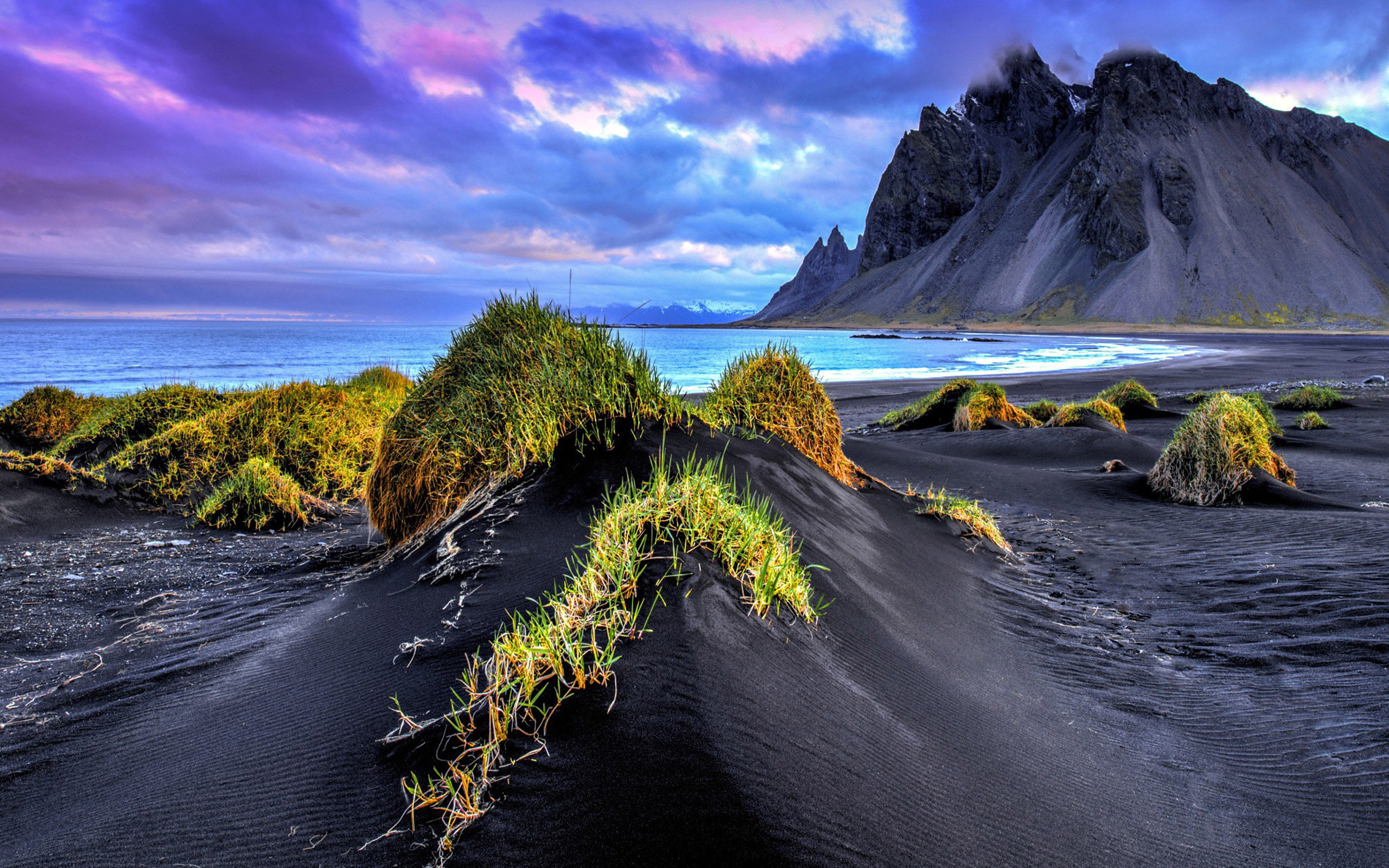 Landscape-Nature-Iceland-sandy beach-grass-black-sand-sea-rocky mountains sky with dark clouds-HD Wallpaper-2560×1600