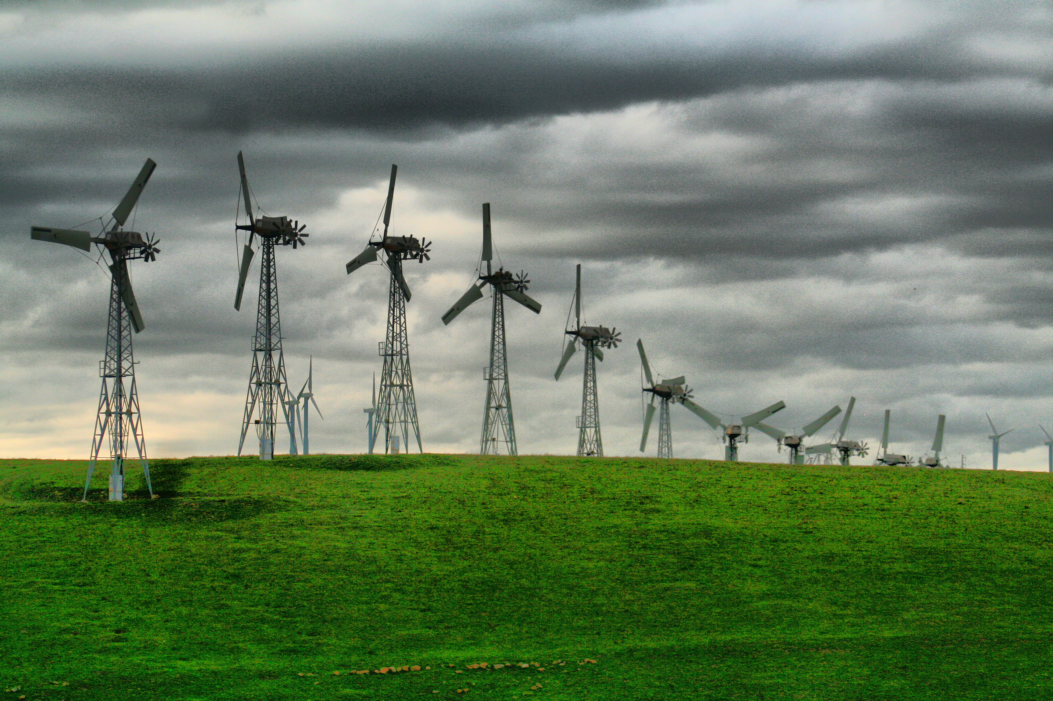 grey windmills on green grass field under cloudy sky, Northern California