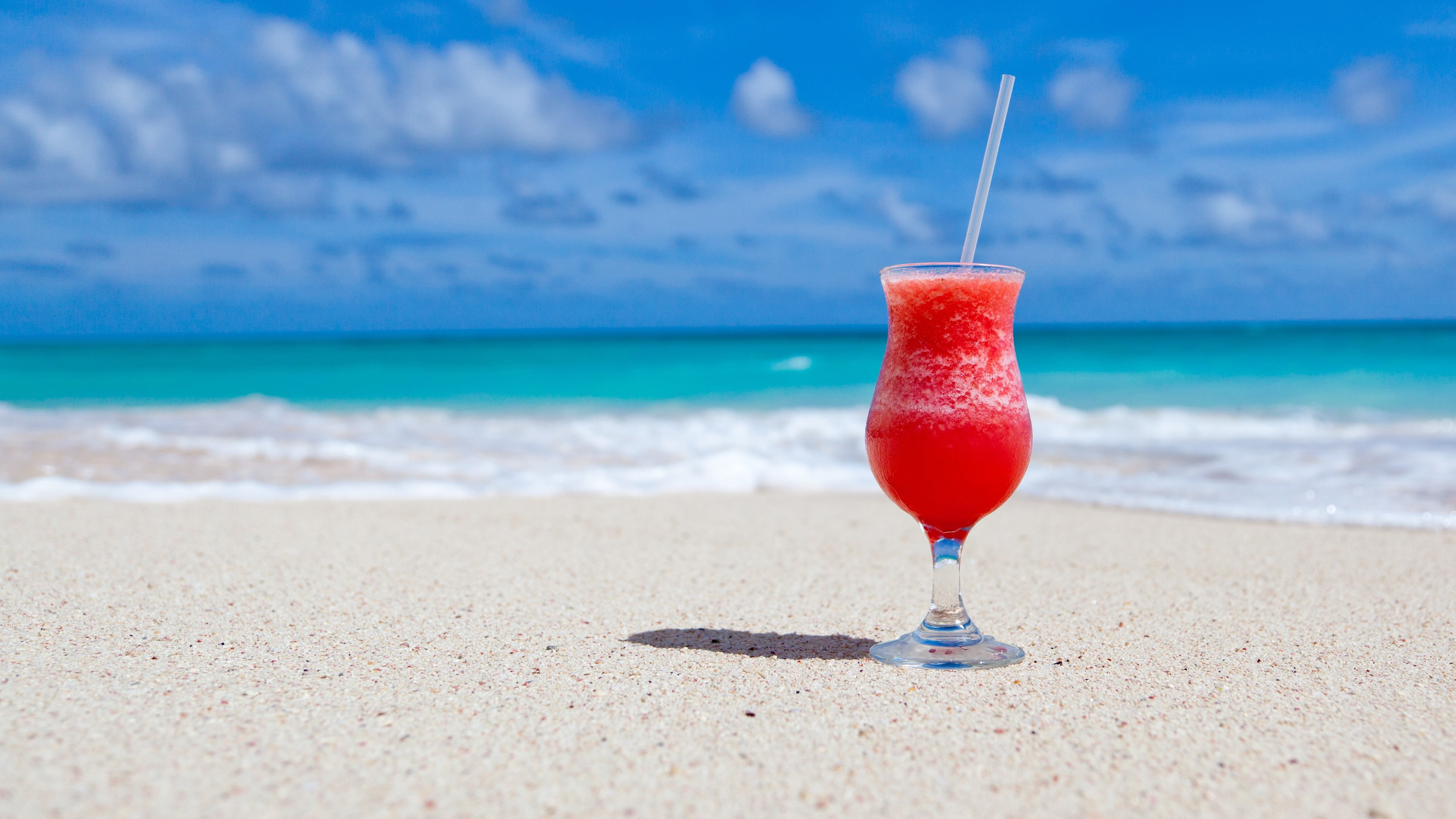 clear long-stem glass, beach, sand, cocktails, tropical, sea